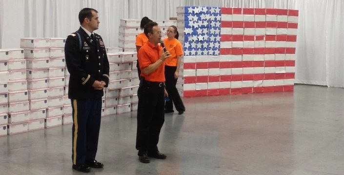 A group of people standing in front of an american flag.