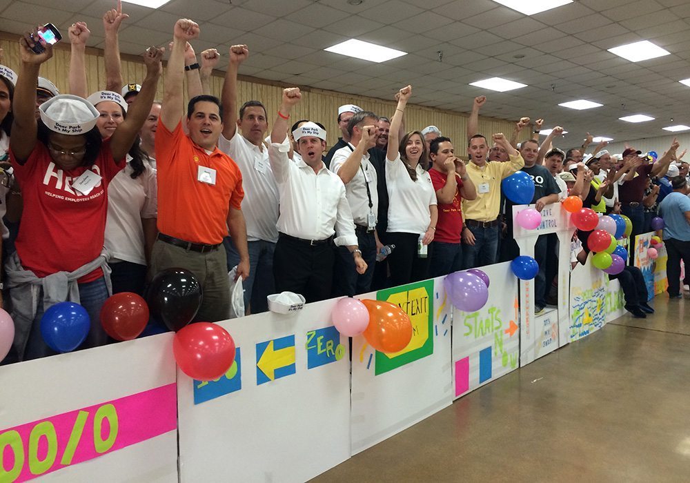 A group of people standing in a room with balloons.
