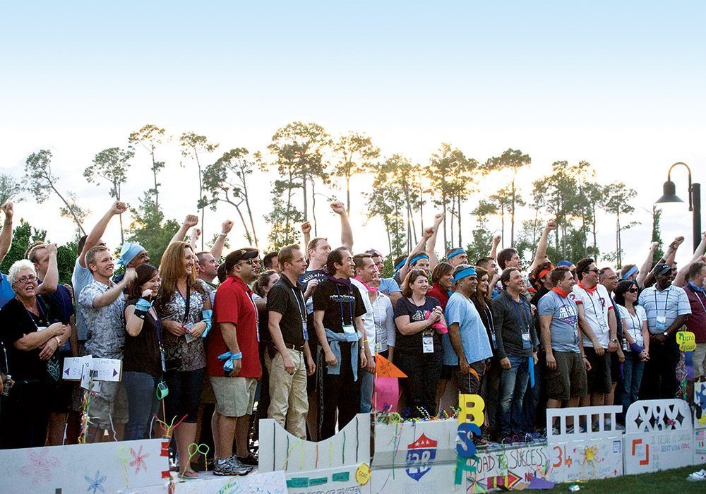 A group of people standing in front of a fence.