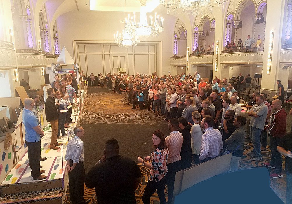 A crowd of people standing in a large room.