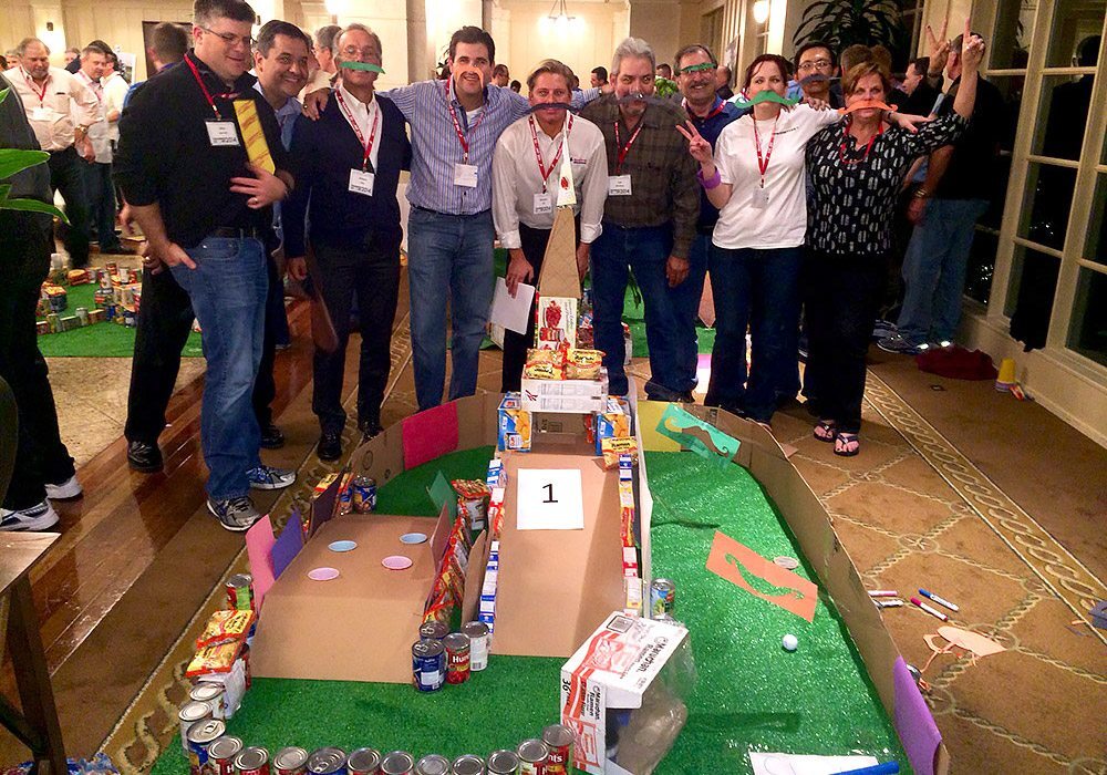 A group of people posing in front of a model of a city.