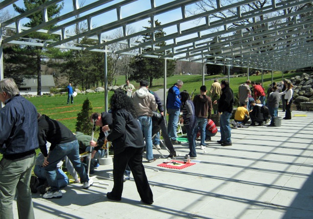 A group of people standing under a metal structure.