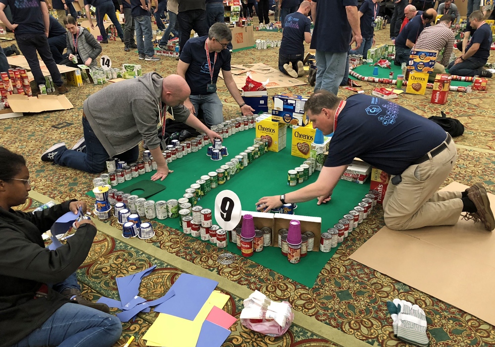 A group of people working on a model of a building.