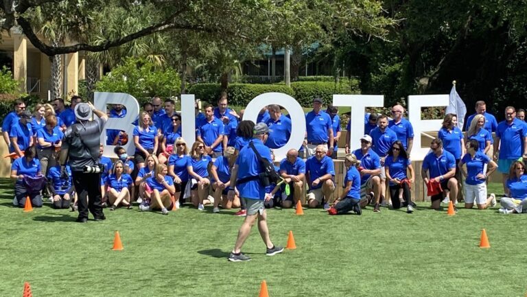 A group of people posing in front of a sign.