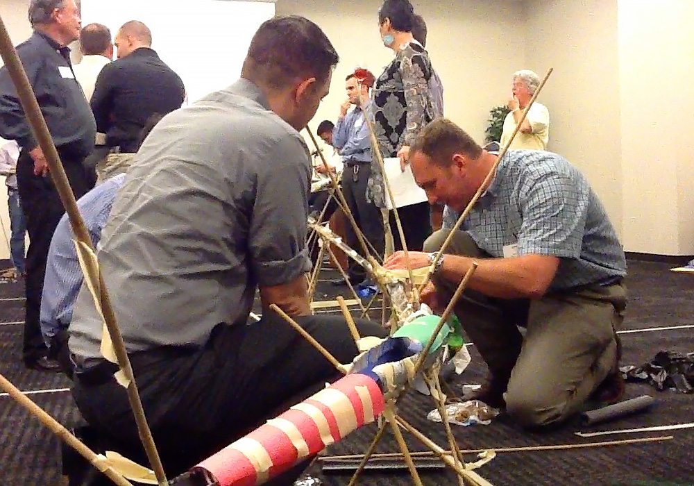 A group of people working on a project with sticks.