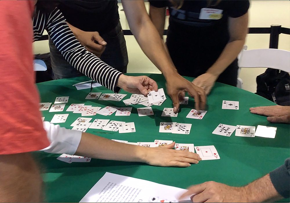 A group of people playing cards at a table.