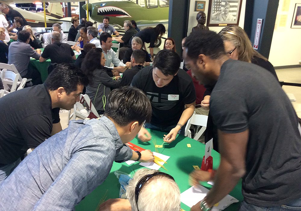 A group of people sitting around a table playing a game.