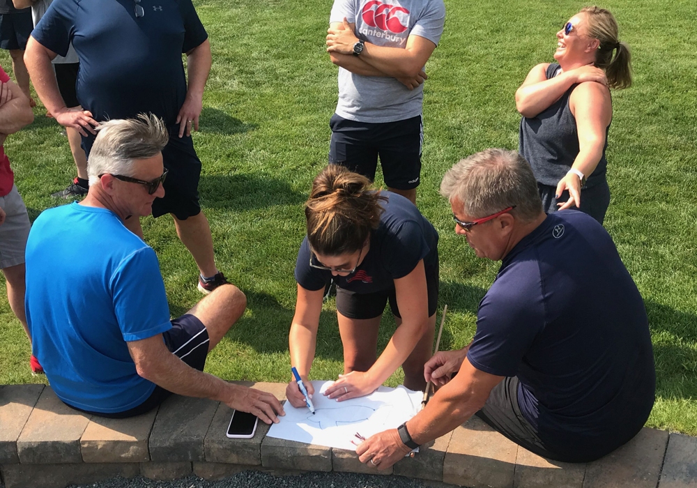 A group of people gathered around a piece of paper.