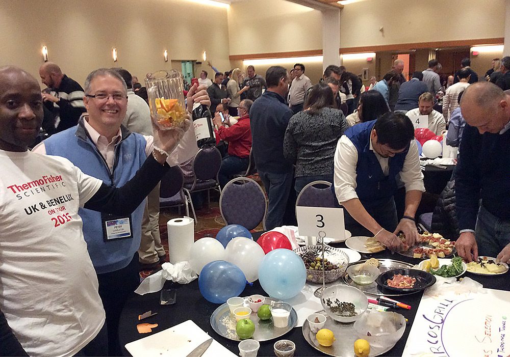 A group of people standing around a table.