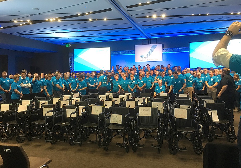 A group of people in blue shirts standing in front of a stage.