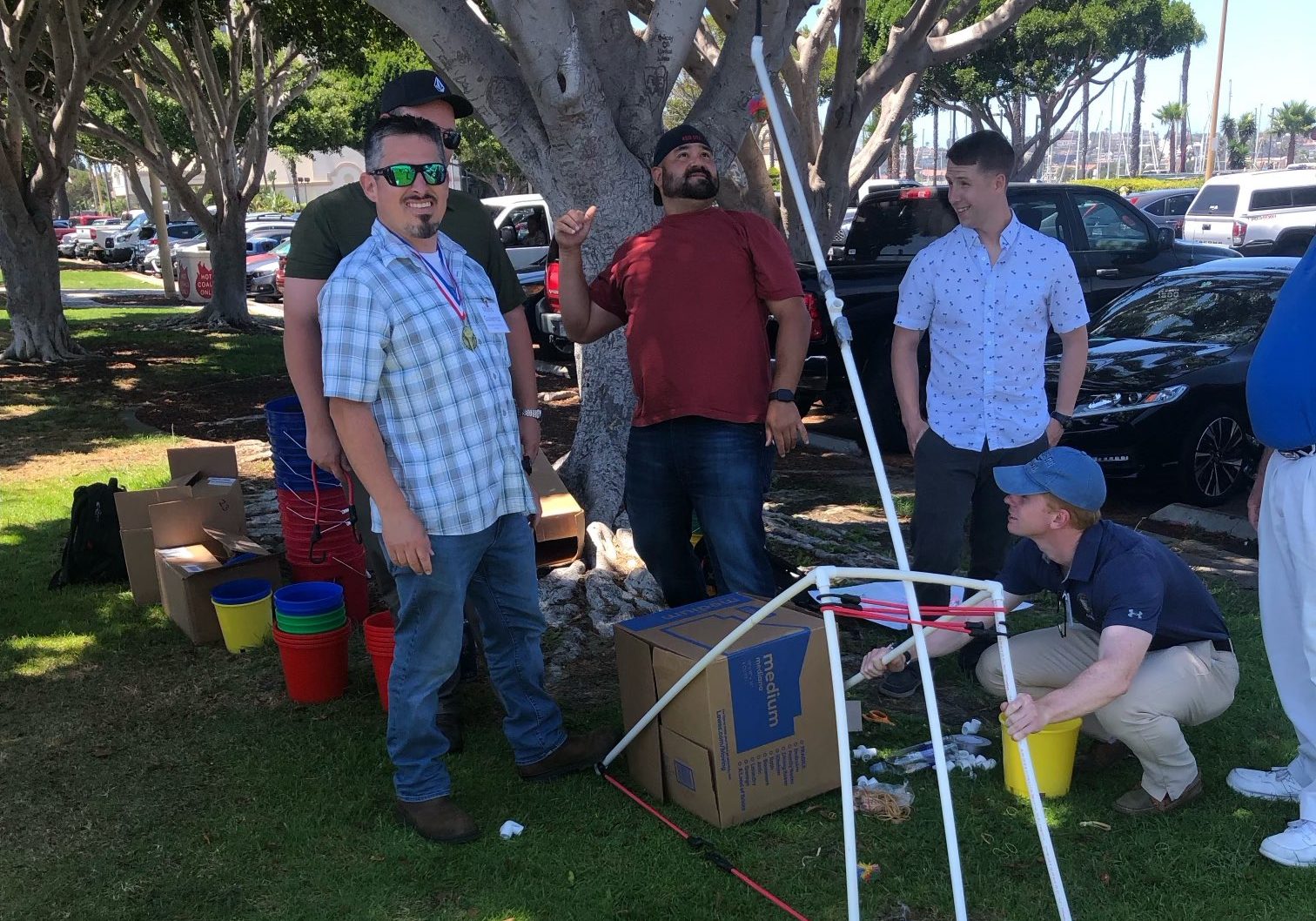 A group of people standing in a grassy area.