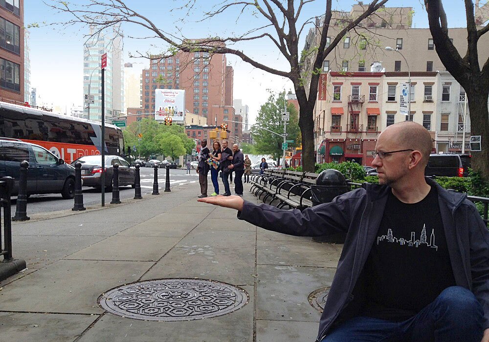 A man kneeling on a sidewalk.