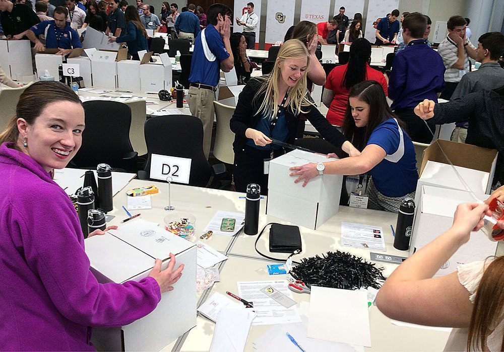 A group of people standing around a table with boxes.