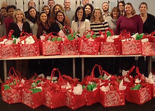 A group of people posing for a photo with gift bags.