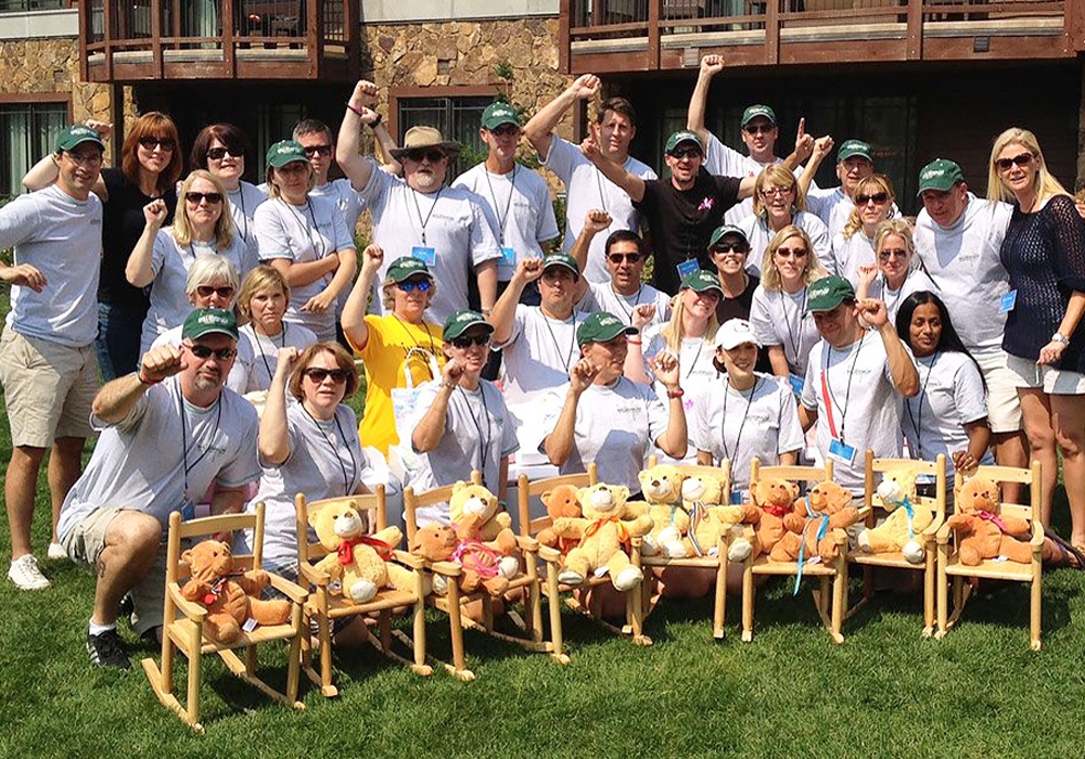 A group of people posing with teddy bears.