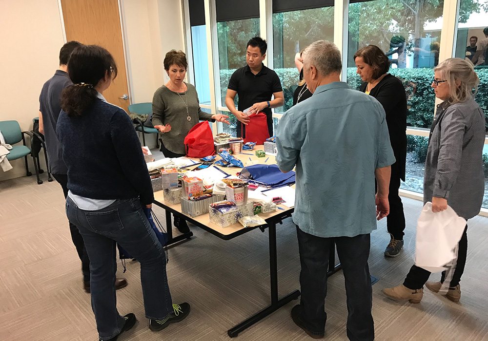 A group of people standing around a table.