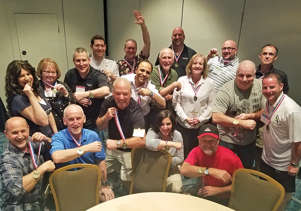 A group of people posing for a picture in a conference room while showcasing their recent toy donation efforts.