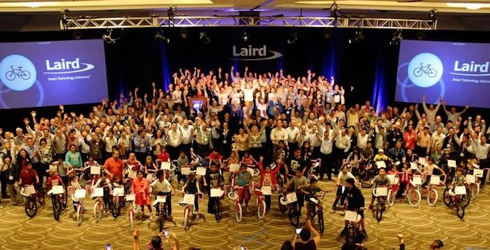 A large group of people standing in front of a stage.