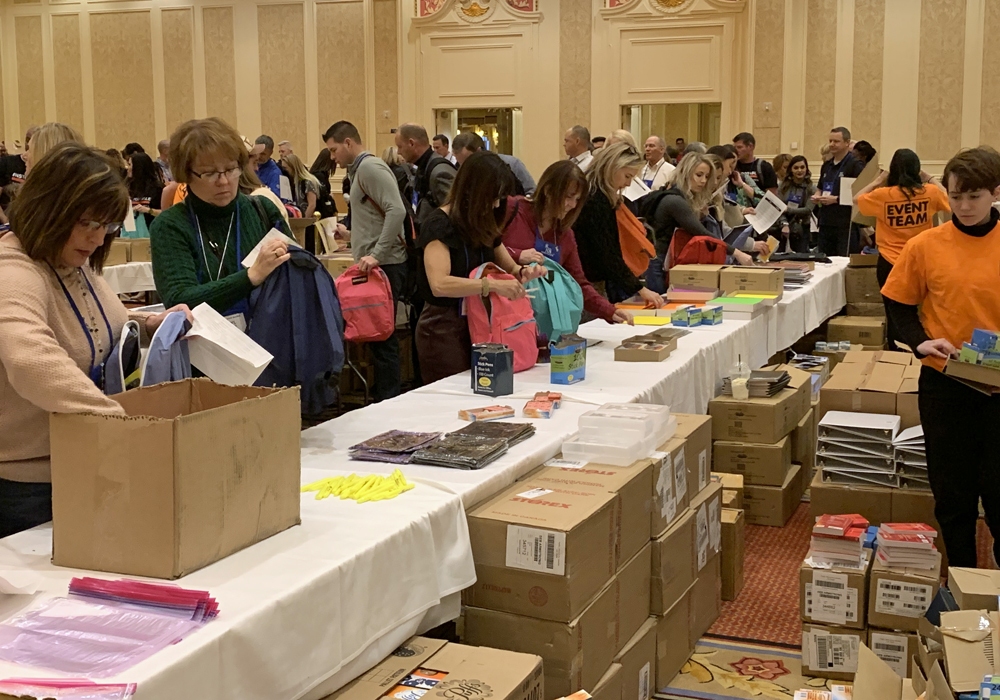 A group of people standing in front of a table full of boxes.