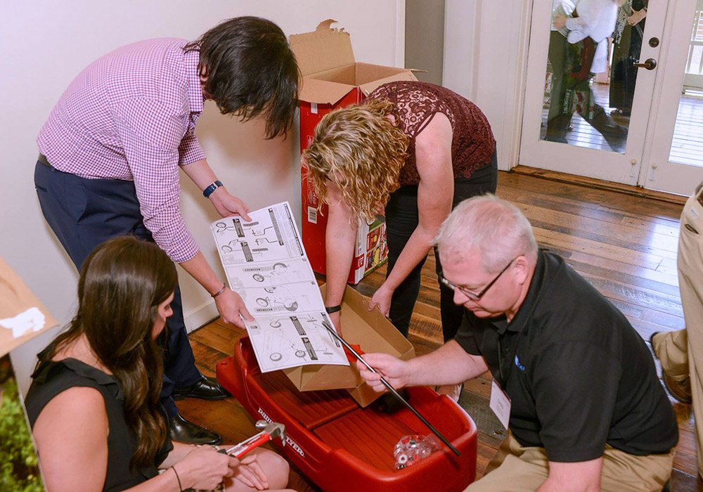 A group of people opening up a box of coca cola.
