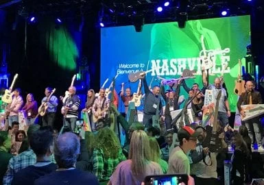 A group of people standing on stage with guitars.