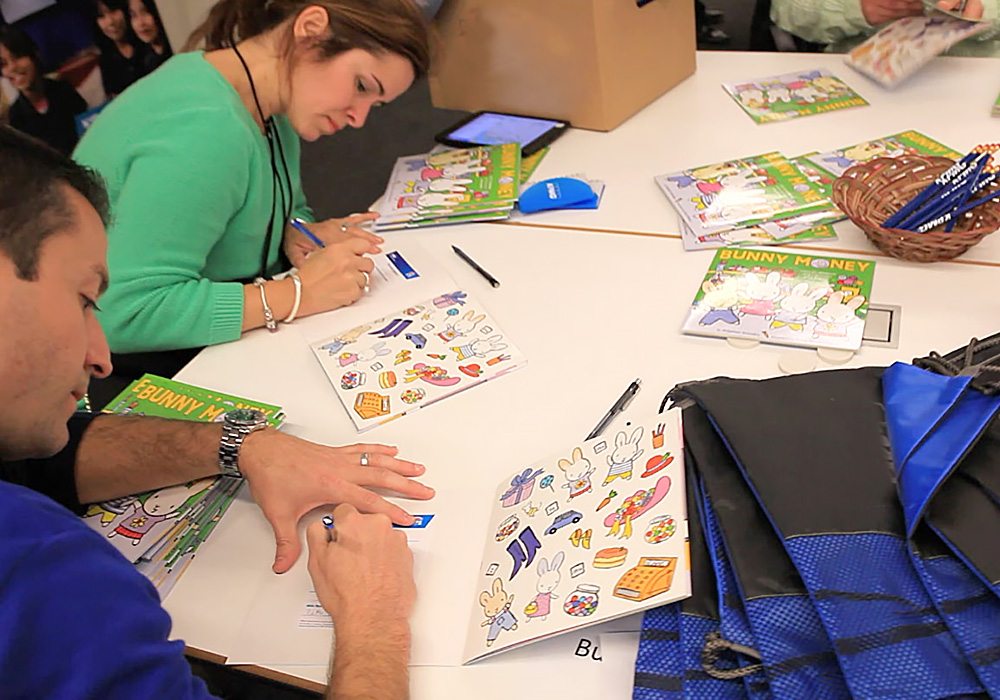 A group of people sitting at a table with books.