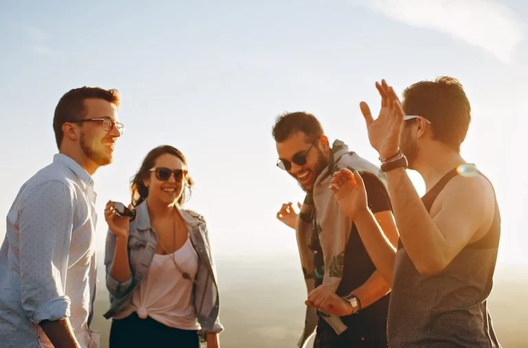 A group of friends standing on top of a mountain.