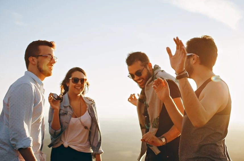 A group of friends standing on top of a mountain.