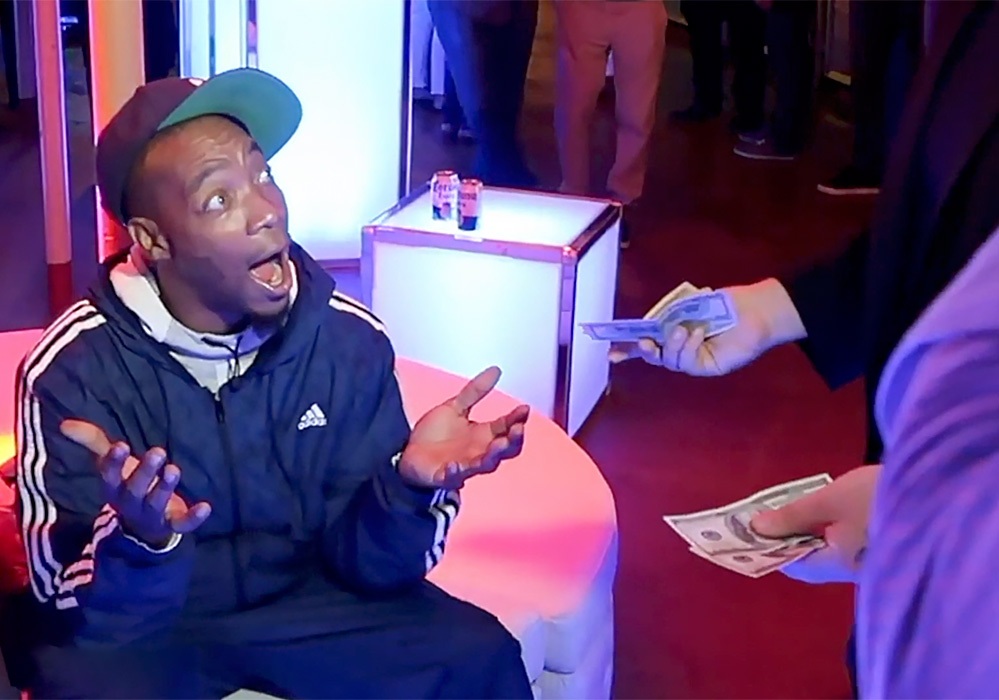 A man sitting on a couch with money in his hand.