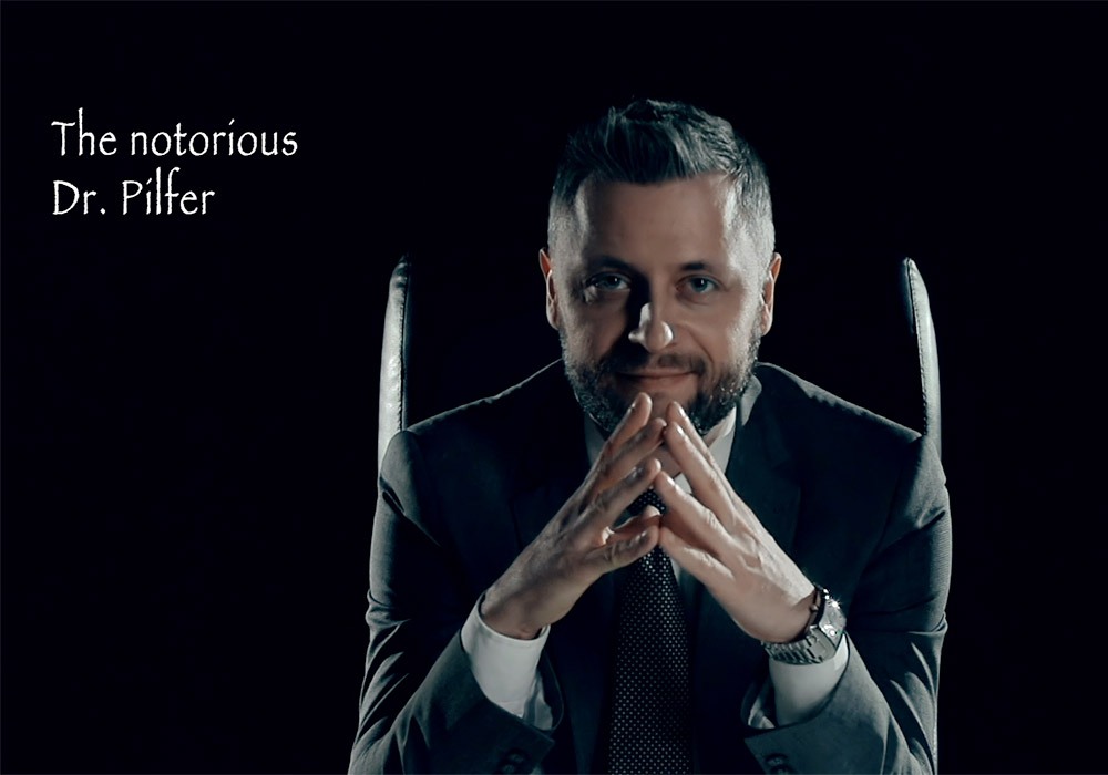 A man in a suit is sitting in a chair with the words the motorious dr filler.