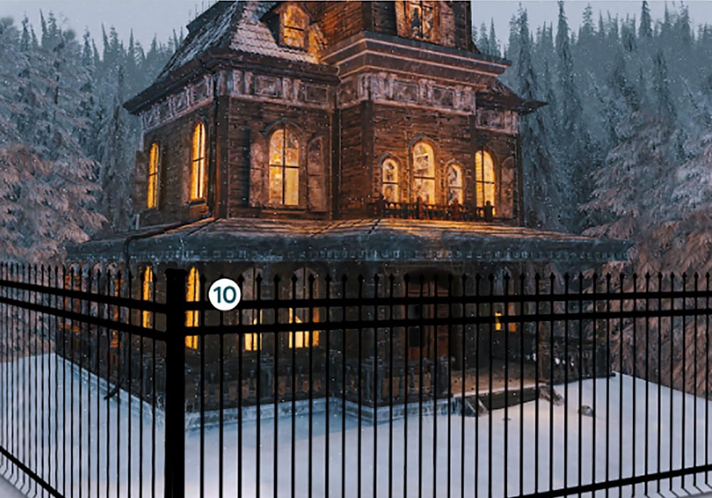 A victorian house with a fence in the snow.