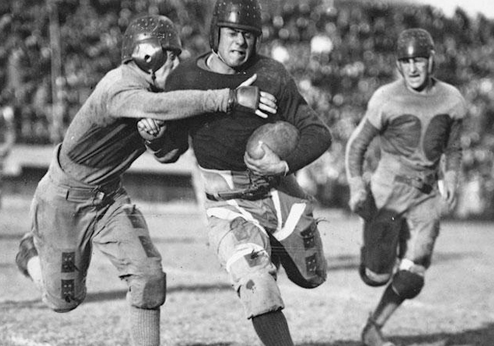A group of football players running with the ball.