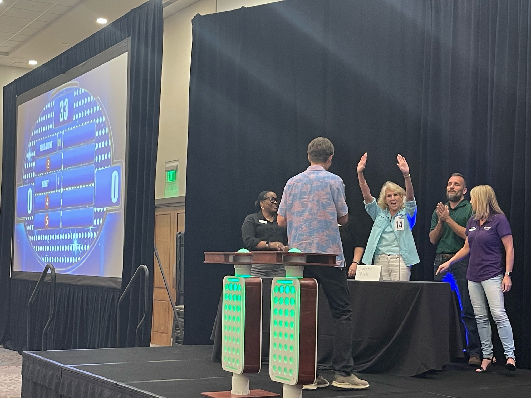A group of people standing on a stage and waving their hands.