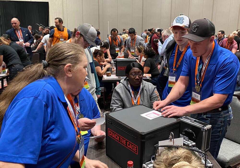 A group of people standing around a table at a convention.