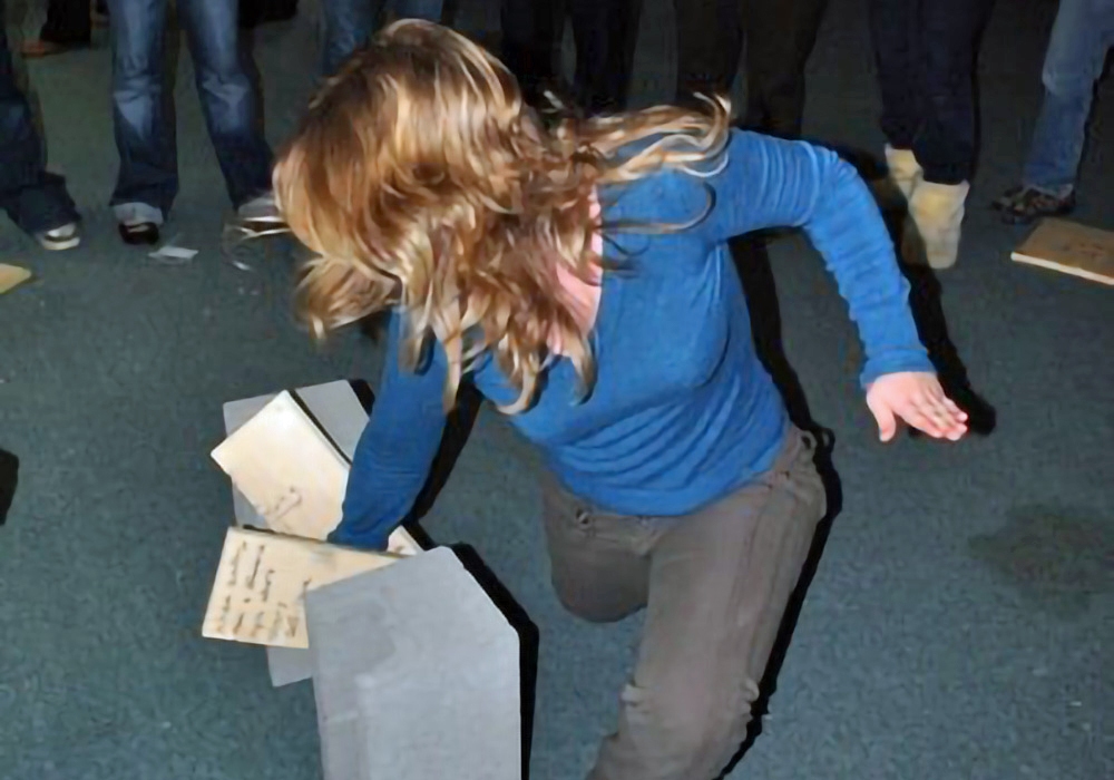 A woman crawling on top of a pile of bricks.