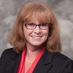 A woman wearing glasses and a red shirt.