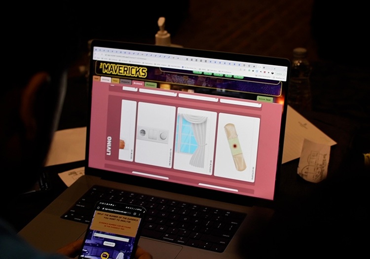 A person is using a laptop with a phone on it.