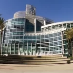A large building with palm trees in front of it.