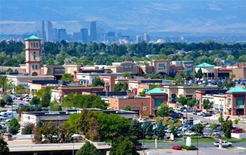 An aerial view of a city in colorado with mountains in the background.