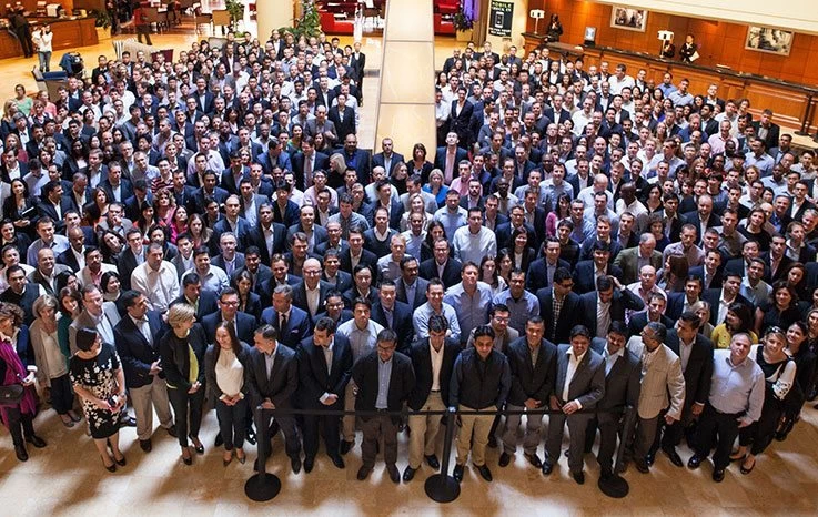 A large group of people posing for a picture in a lobby.