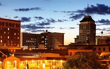 A city skyline at dusk with tall buildings in the background.
