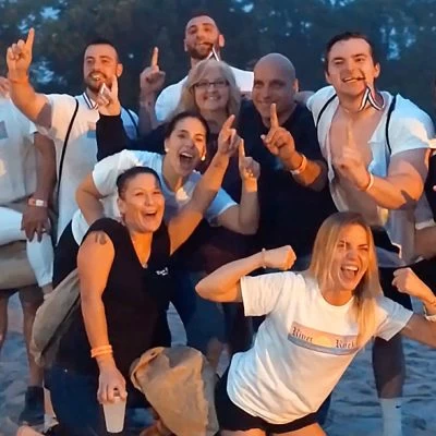 A group of people posing for a photo on the beach.