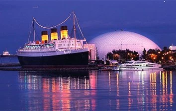 A large ship docked in the water at night.