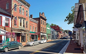 A street lined with brick buildings and parked cars.