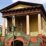 A building with columns and stairs on a city street.