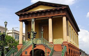 A building with columns and stairs on a city street.