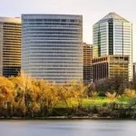 A city skyline with trees and a river.