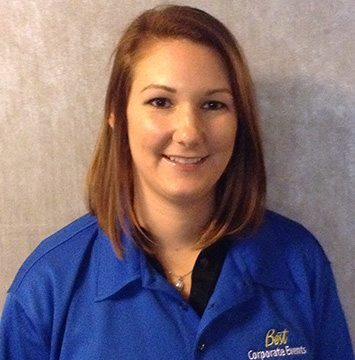 A woman in a blue shirt is smiling.