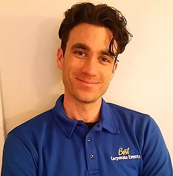 A man in a blue shirt is smiling.