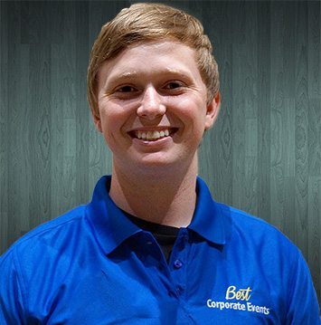 A man in a blue polo smiles for the camera.